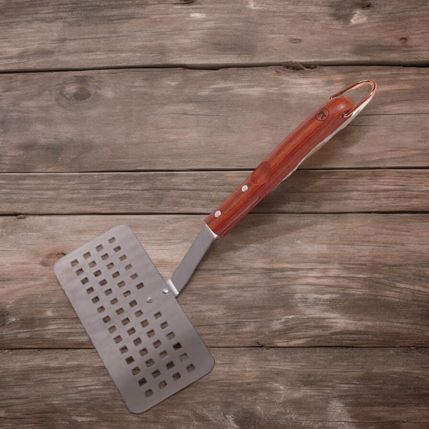 Wide metal spatula with square slots and a wooden handle.