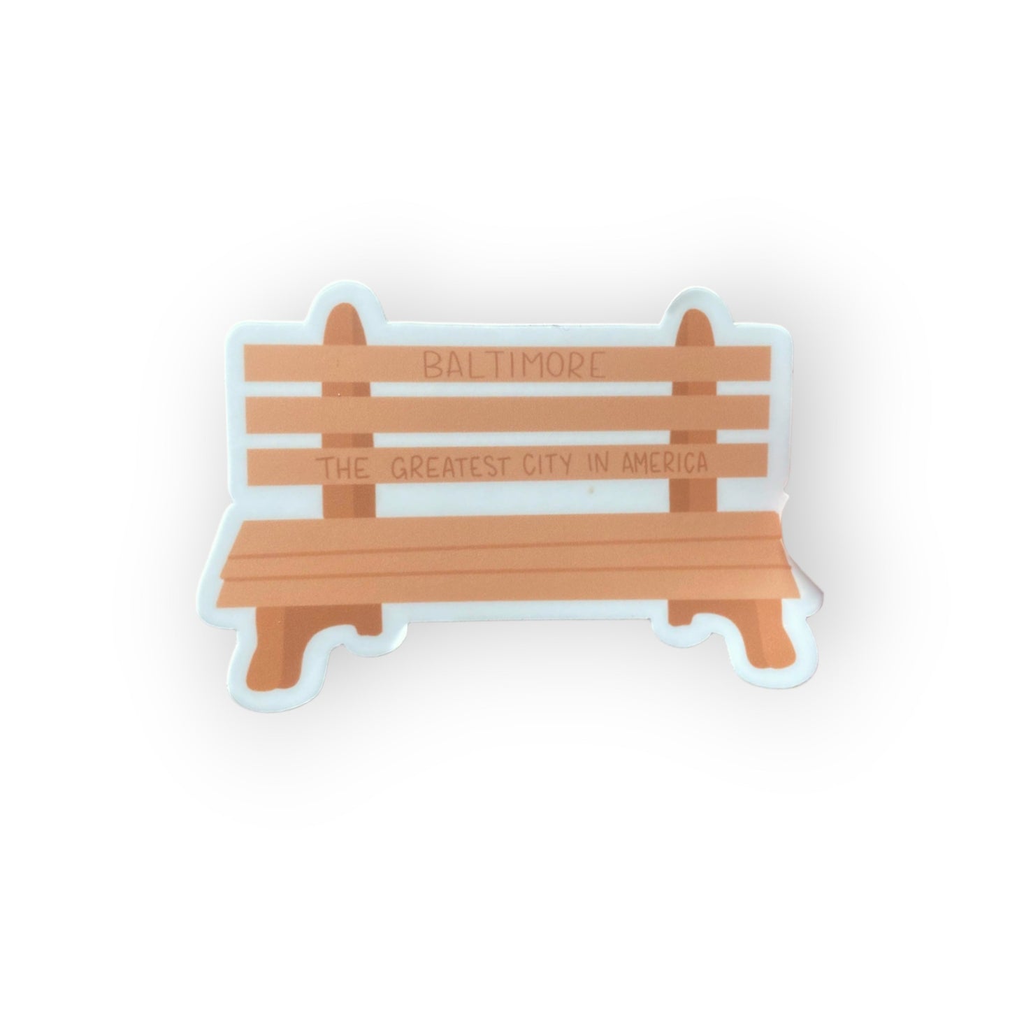 picture of a sticker of a wooden bench that reads Baltimore, the greatest city in Americal.