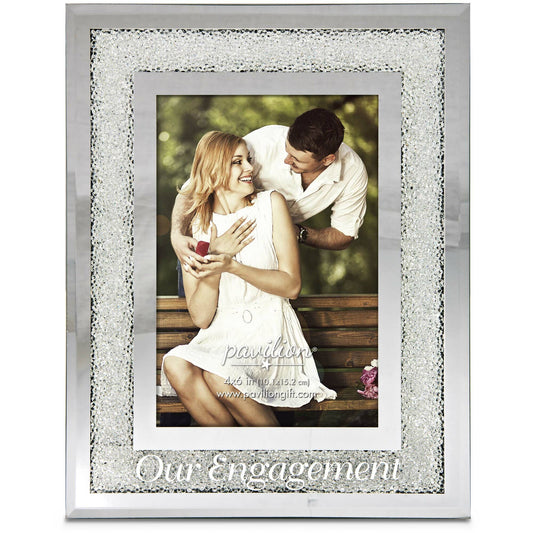 A 7" x 9" glass photo frame featuring delicate acrylic beading and the sentiment "Our Engagement" printed below the 4" x 6" photo display. Includes an easel stand for tabletop placement. Perfect for newly engaged couples or as a keepsake gift.

