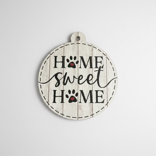 Decorative wall signs with 'Home Sweet Home' and paw prints on a wooden surface.