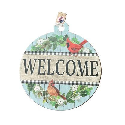Round wooden sign with 'WELCOME' text and cardinal birds on a wooden surface