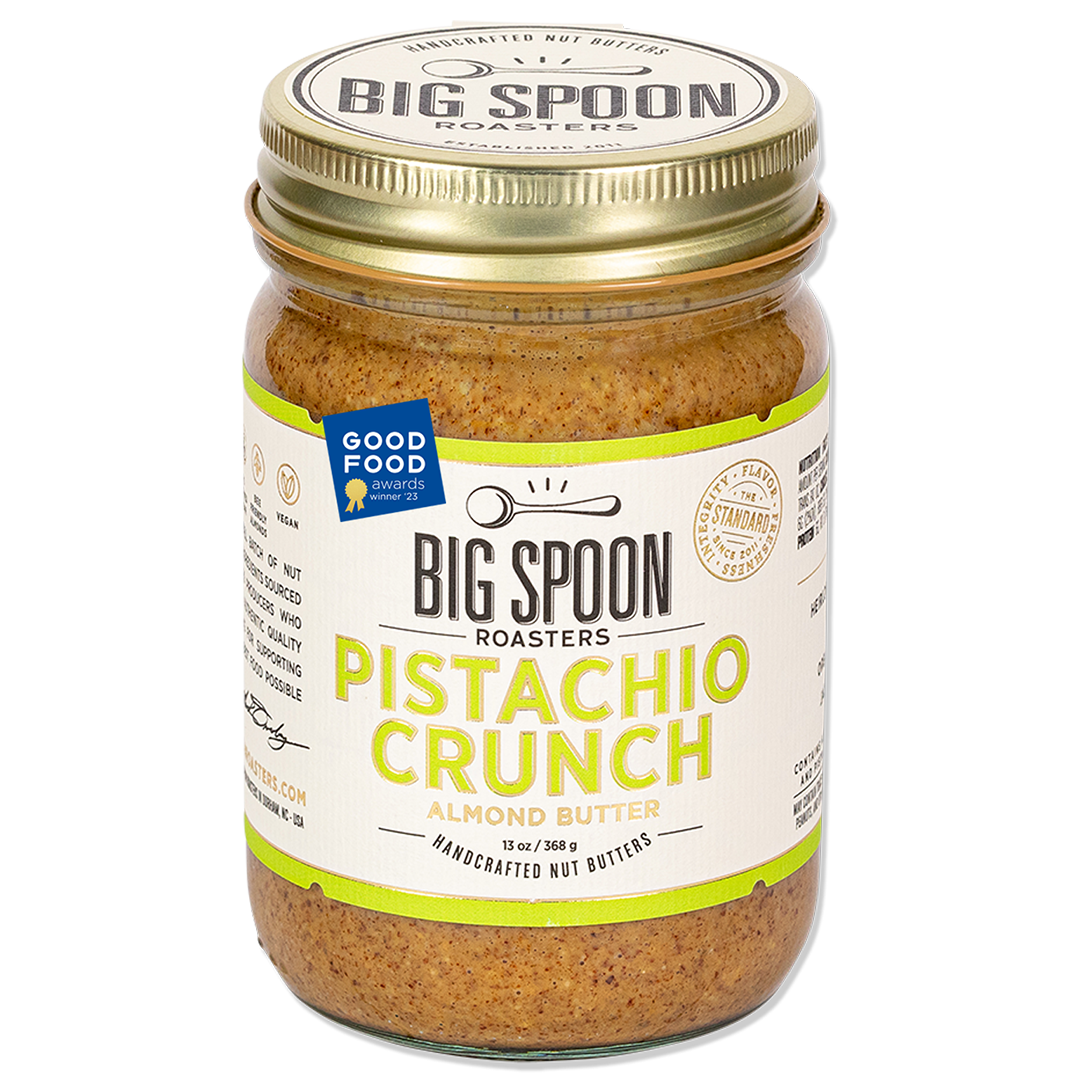 Jar of Big Spoon Roasters Pistachio Crunch Almond Butter with a Good Food Award badge on a white background