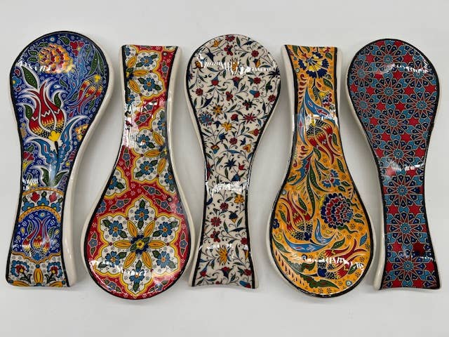 Five colorful ceramic spoons with intricate patterns on a white background