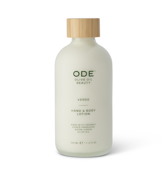 A pump bottle of ODE Olive Oil Beauty Hand & Body Lotion with the label 'Verde' indicating its green, natural scent. The bottle is white and has a wooden cap.